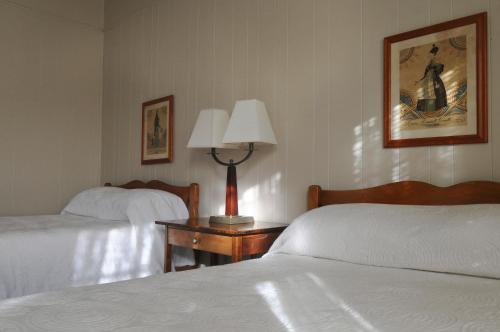 a hotel room with two beds and a lamp on a table at Hotel Coolidge in White River Junction