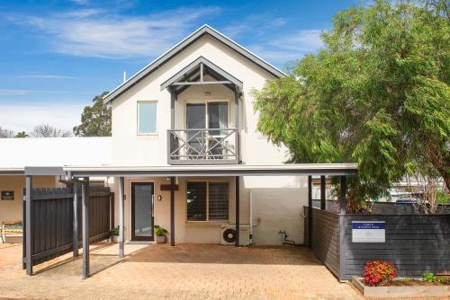 a white house with a tree in front of it at @WinenWaves Margaret River in Margaret River Town
