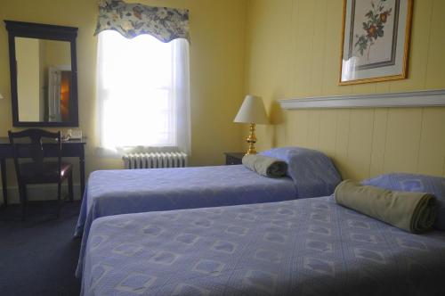 a hotel room with two beds and a window at Hotel Coolidge in White River Junction