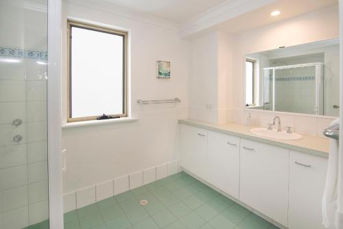 a white bathroom with a sink and a mirror at @WinenWaves Margaret River in Margaret River Town