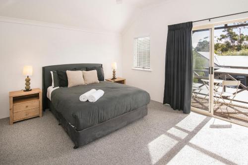 a bedroom with a large bed and a balcony at @WinenWaves Margaret River in Margaret River Town