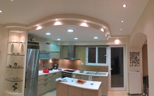 a kitchen with a vaulted ceiling with a refrigerator at A1 Elegant Vouliagmeni apt in a Unique Spot in Athens
