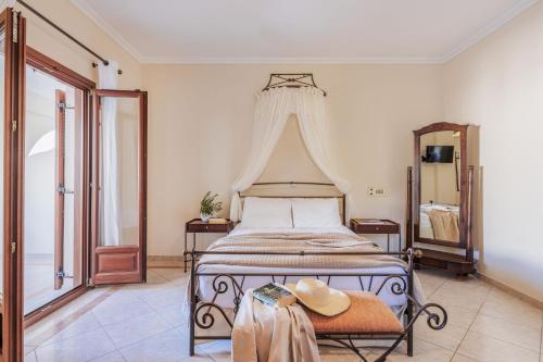 a bedroom with a bed with a hat on a table at Epavlis Hotel & Spa in Kamari