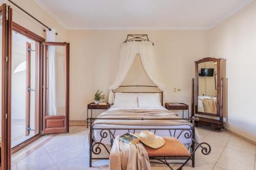 カマリにあるEpavlis Hotel & Spaのベッドルーム1室(テーブルに帽子付)