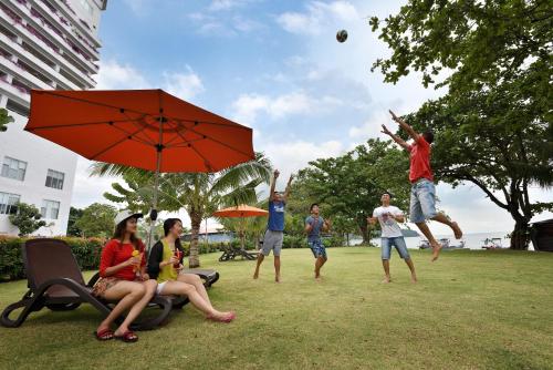 people sitting on top of a grass covered field at Lexis Suites Penang in Bayan Lepas
