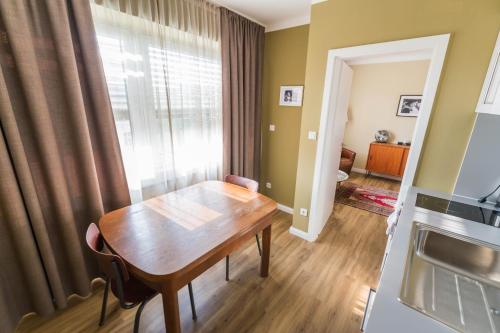 a dining room with a table and a kitchen at Luis City Apartments Regensburg in Regensburg