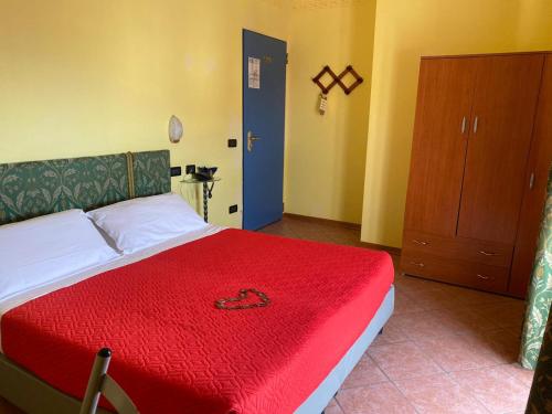 a bedroom with a bed with a red blanket on it at Hotel Villa Colombo in Lido di Camaiore