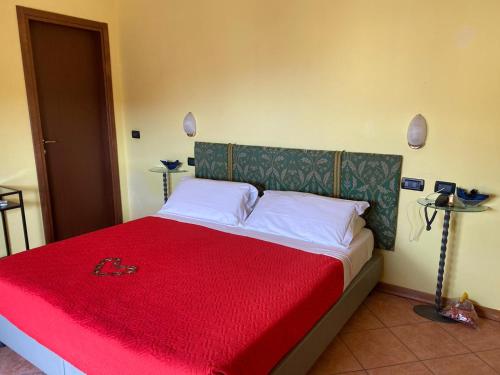 a bedroom with a bed with a red blanket at Hotel Villa Colombo in Lido di Camaiore