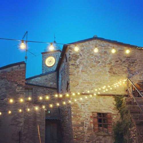 a building with a clock tower with lights on it at Il Cavalier Veggiani B&B in Mercato Saraceno