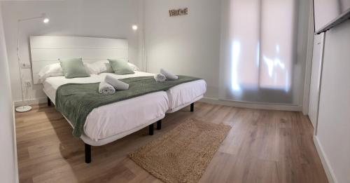 um quarto com uma cama grande e um cobertor verde em TeruelHOME I Con Encanto y parking em Teruel