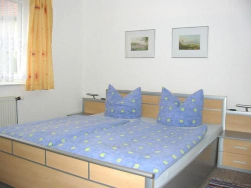 1 dormitorio con 1 cama con almohadas azules en Ferienhof Schwäbe, en Lommatzsch