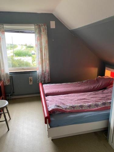a bedroom with a bed in a room with a window at Bestemorhuset in Kariel