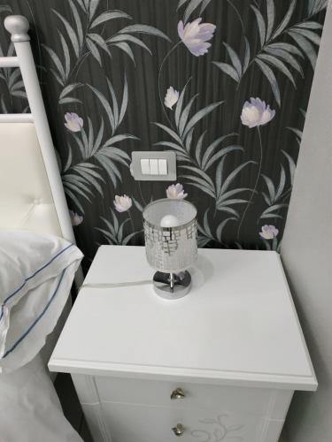 sypialnia z białą szafką nocną z tapetą kwiatową w obiekcie Guesthouse Aaron2 w mieście Neapol