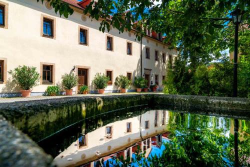 a pool of water in front of a building at Landhotel Gut Wildberg mit Sauna in Meißen