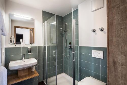 a bathroom with a shower and a toilet and a sink at Drexel`s Parkhotel am Schloss in Krumbach
