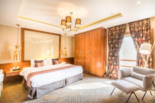 a hotel room with a large bed and a chair at Grand Plaza Hotel - Takhasosi Riyadh in Riyadh