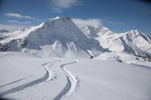 a person is skiing down a snow covered mountain at Naturhaus am Arlberg in Warth am Arlberg