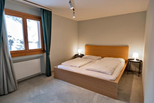 Un dormitorio con una cama grande y una ventana en Chesa Fuolla Rosa - Celerina, en Celerina