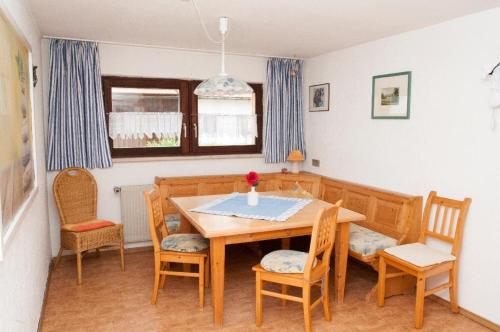 a dining room with a wooden table and chairs at Ferienwohnung Winterstetter Am Waldglasgarten in Riedlhütte