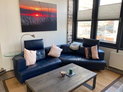a living room with a blue couch and a coffee table at Luxus-Loft-Sylt in Westerland (Sylt)