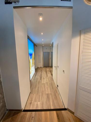 an empty hallway with white walls and wood floors at Luxus-Loft-Sylt in Westerland (Sylt)
