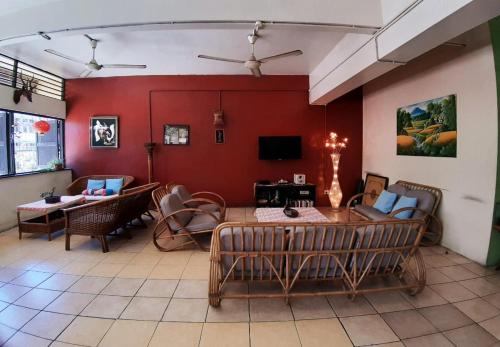 uma sala de estar com paredes vermelhas e uma mesa e cadeiras em Akinabalu Youth Hostel em Kota Kinabalu