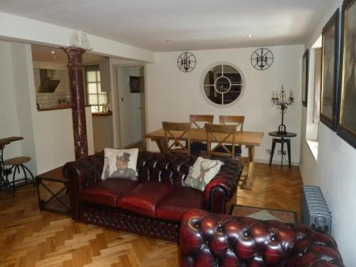 a living room with a leather couch and a table at Old town Brewery Apartment in Edinburgh