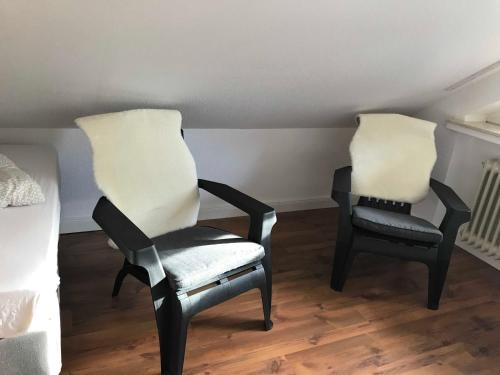 two chairs sitting next to each other in a room at Wohnen am Wanderweg II in Aurich