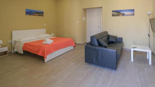 a bedroom with a bed and a couch and a chair at Royal Dante in Naples
