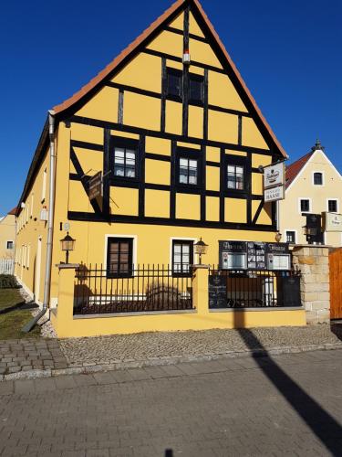 un edificio amarillo y negro con un edificio negro y amarillo en Ferienwohnung Fachwerkhaus, en Dresden