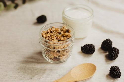 a glass jar of granola and a spoon and blackberries at Mayflower Hotel Malta in St Paul's Bay
