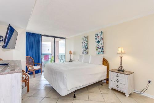 a bedroom with a bed and a balcony at Palms Resort 1502 in Myrtle Beach