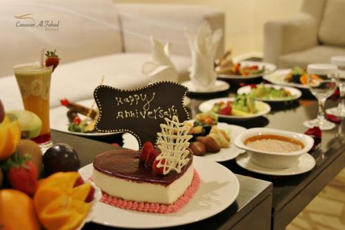 a table topped with a cake with a happy anniversary sign at Carawan Al Fahad Hotel in Riyadh