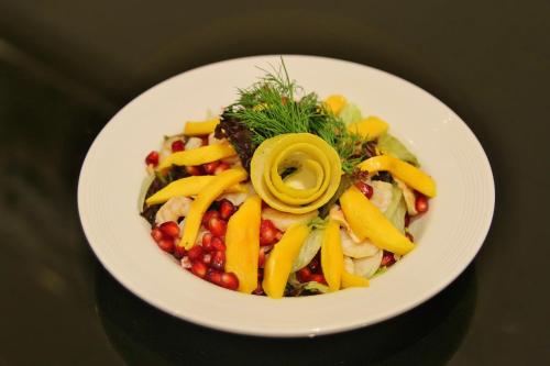 a white plate of food with fruit and vegetables at Carawan Al Fahad Hotel in Riyadh