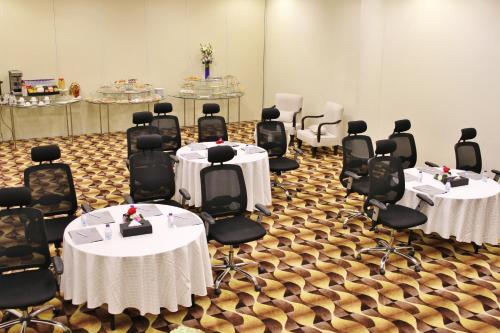 a conference room with tables and chairs with white table cloth at Carawan Al Fahad Hotel in Riyadh