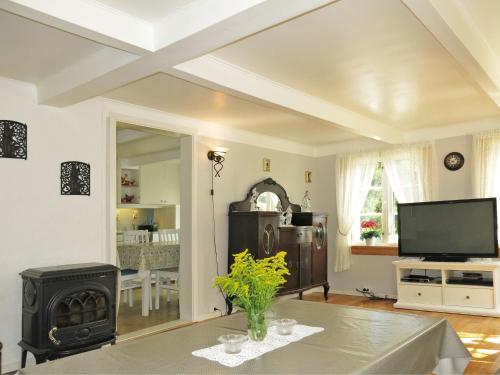 a living room with a table and a stove at Holiday Home Øygårdsheia - SOO615 by Interhome in Grimstad