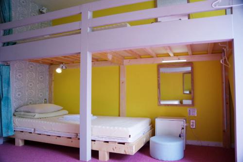 a bedroom with two bunk beds and a mirror at Ten to Sen Guesthouse in Takamatsu