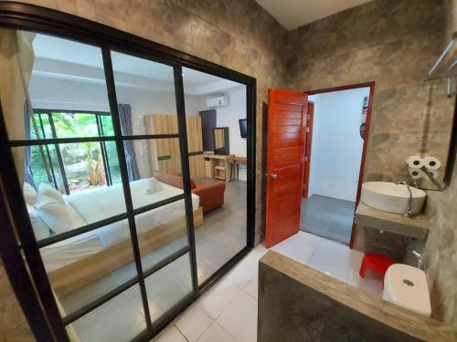 1 dormitorio y baño con lavabo. en Malinee Resort en Bang Tao Beach