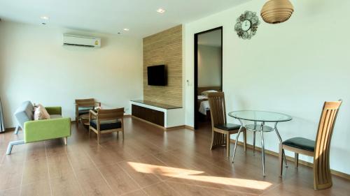 a living room with a table and chairs at Ravin Home ราวินโฮม in Nakhon Nayok