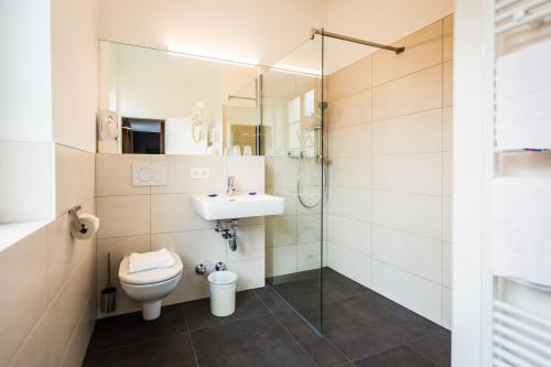 a bathroom with a toilet and a sink and a shower at Hotel Markus Sittikus Salzburg in Salzburg