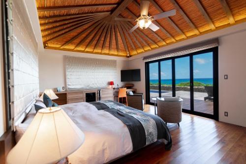 a bedroom with a bed with a view of the ocean at Villabu Resort in Miyako Island