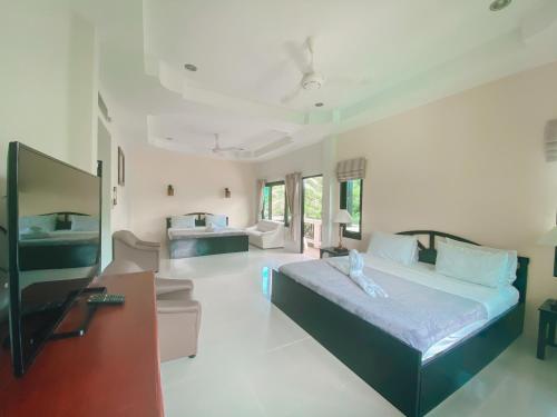 a bedroom with a bed and a living room at Aumpai Luxury in Lamai