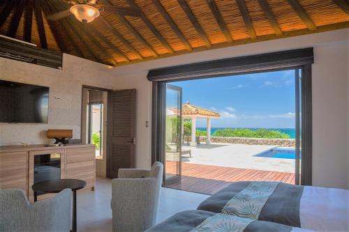 a bedroom with a bed and a view of the ocean at Villabu Resort in Miyako-jima