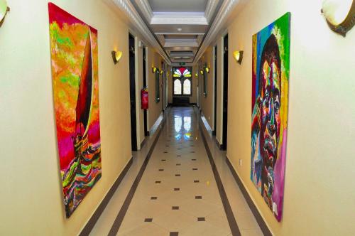 a hallway with colorful paintings on the walls at Golden Tulip Stone Town Boutique in Zanzibar City