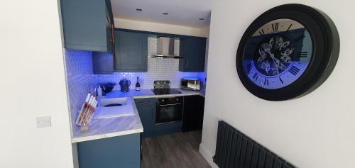 una cocina con un reloj grande en la pared en Spa House Retreat en Whitby