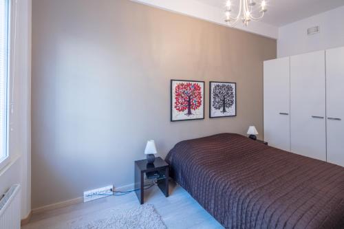 um quarto com uma cama e duas fotografias na parede em Luxury Seaside Apartments em Helsinque
