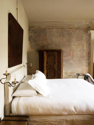 a bedroom with a white bed with a wall at Palazzo Albricci Peregrini in Como