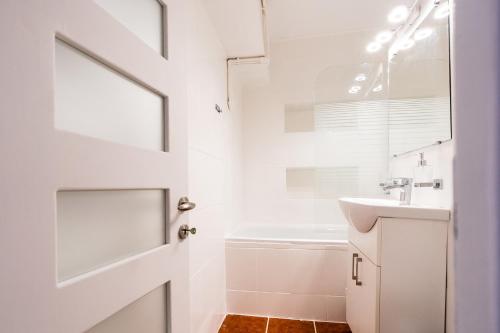 ein weißes Badezimmer mit einem Waschbecken und einem Spiegel in der Unterkunft Luna Rosie in Deva