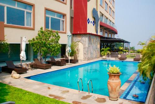 a swimming pool in front of a building at Kiriri Garden Hotel in Bujumbura
