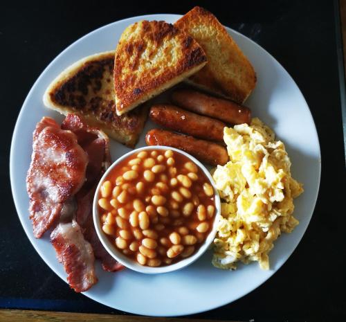 a plate of breakfast food with eggs beans and toast at The Tree-house B&B in Ballymena